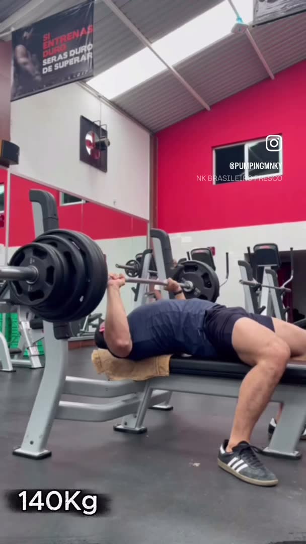 Coach Pumping beim Bankdrücken im hell ausgeleuchteten Gym