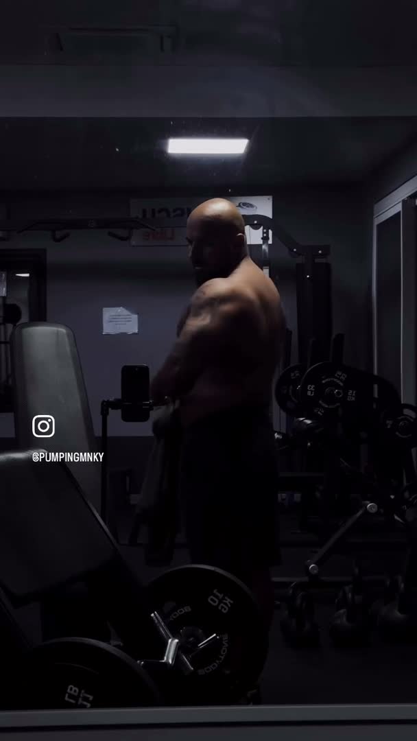 Rückenansicht von Coach Pumping im abgedunkelten Gym